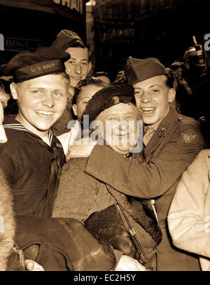Jubilant American soldier hugs femme anglais maternelle et la victoire sourit lumière les visages des professionnels, hommes et les civils à Piccadilly Circus, Londres, célébrant la capitulation sans condition. L'Angleterre, le 7 mai 1945. La FPC. Melvin Weiss. (Armée) Banque D'Images