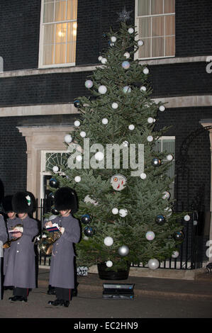 Londres, Royaume-Uni. 8 Décembre, 2014. Noël commence officiellement à Downing Street le lundi soir, quand l'arbre à l'extérieur no 10 est allumé pour la première fois cette saison devant des invités avec la bande du Welsh Guards jouant des chants de Noël à l'arbre. Credit : Malcolm Park editorial/Alamy Live News Banque D'Images