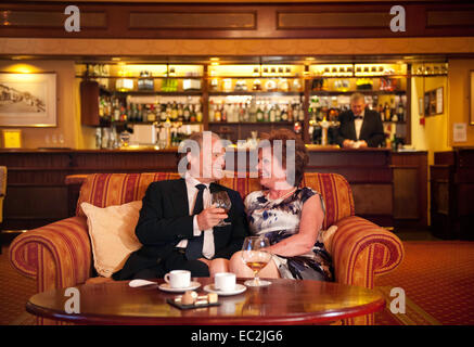 Un vieux couple ayant un verre ensemble dans un bar d'hôtel en Angleterre Banque D'Images