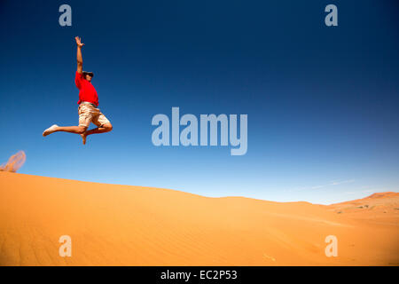 L'Afrique, la Namibie. La Namibie désert. Sossusvlei, Naukluft Park. Man Jumping off dune. Parution du modèle. Banque D'Images