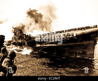 Uss Santa Fe jette aux côtés de uss franklin assistance après carrier avait été frappé et incendié par un bombardier en piqué japonais. mars 1945. (Marine) Banque D'Images