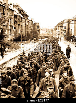 L'interminable cortège des prisonniers allemands capturés à l'automne de Aix-la-chapelle marche dans les rues de la ville en ruine de captivité. Allemagne, octobre 1944 . Banque D'Images