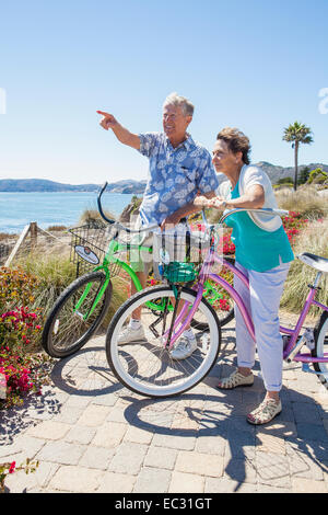 Un couple d'adultes sur les bicyclettes admire la vue sur l'océan, Pismo Beach, Central Coast, Californie, États-Unis d'Amérique Banque D'Images