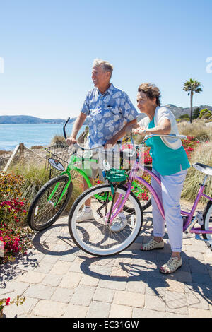 Un couple d'adultes sur les bicyclettes admire la vue sur l'océan, Pismo Beach, Central Coast, Californie, États-Unis d'Amérique Banque D'Images