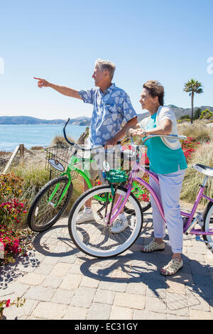 Un couple d'adultes sur les bicyclettes admire la vue sur l'océan, Pismo Beach, Central Coast, Californie, États-Unis d'Amérique Banque D'Images