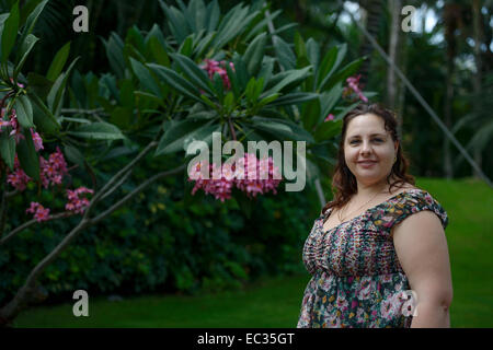 Waist up portrait of mid adult woman sur fond tropical. Banque D'Images