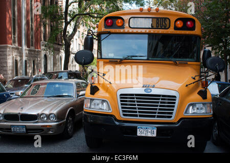 United States, New York, Manhattan, school bus et voiture Jaguar XJ. Un autobus scolaire (également appelé schoolbus) en Amérique du Nord est Banque D'Images