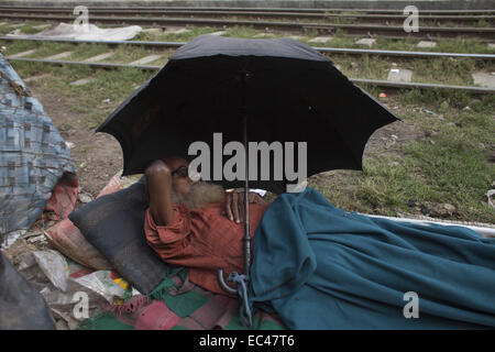 Dhaka, Bangladesh. 9Th Mar, 2014. Un vieil homme étendu près de la ligne ferroviaire à Kamalapur slum Dhaka.Un total de 3,5 millions de personnes vivent dans des taudis, à 4 000 de la Dhaka metropolitan area.les taudis ont été expulsées sans toute réhabilitation et maintenant en hiver, elles souffrent beaucoup.Journée internationale des droits de l'homme 2014 slogan ''Les droits de l'homme 365'' par l'Organisation des Nations Unies. Zakir Hossain Chowdhury Crédit : Fil/ZUMA/Alamy Live News Banque D'Images