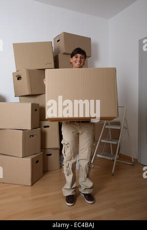 Jeune femme portant un déménagement fort Banque D'Images