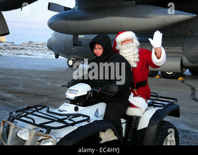 Le Père Noël comme il monte sur un ATV pendant la visite d'un village Inuit à distance dans le cadre de l'Opération Père Noël 16 décembre 2009 à Gambell, Alaska. L'opération Père Noël a remis un don de cadeaux aux pauvres des villages de l'Alaska à distance par le transport de l'Armée de l'air depuis 1951. Banque D'Images