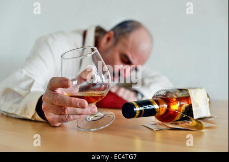 Boissons assis avec un cognac et une bouteille de brandy à la table Banque D'Images