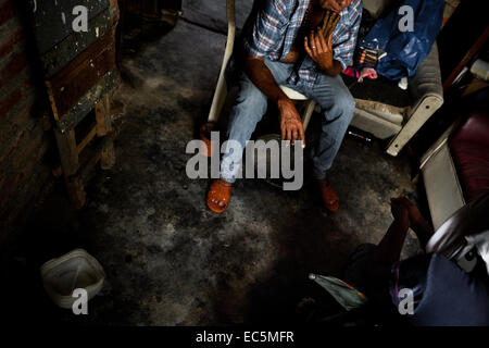 Un chaman urbain colombien (brujo) adore trois cigares avant de commencer le rituel de prédire l'avenir à partir de tabac dans sa maison à Cali, Colombie, le 17 avril 2013. Banque D'Images