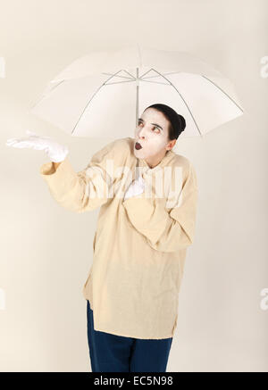 Le clown tenant un parapluie blanc dans la main Banque D'Images