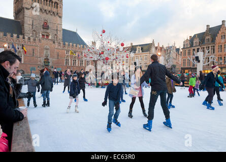 Les gens le patin à glace dans la place du marché (markt ), dans le Bruges (Brugge) Marché de Noël, Belgique, Europe Banque D'Images