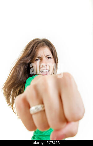 Jolie jeune femme brune forte et en colère jetant poinçon avec fist pour appareil photo avec visage sérieux d'expression. Je blessés et souffrent. Banque D'Images