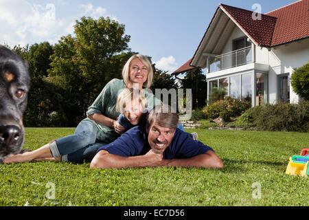 Happy Family lying on lawn in garden Banque D'Images