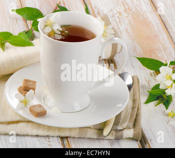 Du thé dans une tasse blanche avec des fleurs . Selective focus Banque D'Images