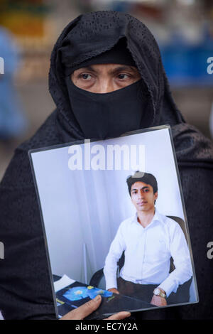 Dhaka, Bangladesh. 10 Décembre, 2014. Une mère avec son fils avait pleurer portrait en face de press club Dhak qui était disparition depuis 2012. Famiy membres ont fait une chaîne humaine tenant des photos de leurs proches disparus durant la célébration de la Journée internationale des droits de l'homme à Dhaka. Selon l'organisation de défense des droits de l'humains Odhikar a déclaré que 150 personnes, pour la plupart de milieux politiques, a été victime d'une disparition forcée entre janvier 2009 et août 2014. Zakir Hossain Chowdhury Crédit : zakir/Alamy Live News Banque D'Images