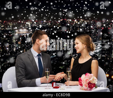 Smiling couple avec boîte cadeau rouge au restaurant Banque D'Images
