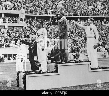 JESSE OWENS (1913-1980) American athlète olympique après avoir remporté le saut en longueur aux Jeux Olympiques d'été de 1936 à Berlin. Deuxième était Luz Long à droite et le troisième était Naoto Tajima Banque D'Images