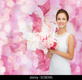 Smiling woman in white dress avec bouquet de roses Banque D'Images