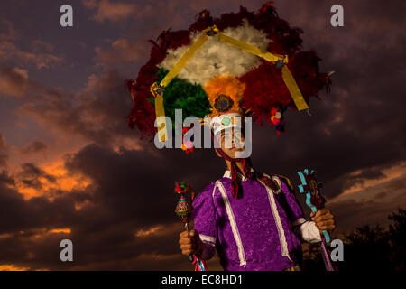 Un danseur en costume traditionnel portant un couvre-chef guerrier zapotèque pose au coucher du soleil pendant le jour de la Fête des Morts connus en espagnol comme d'un de muertos le 29 octobre 2014 à Oaxaca, au Mexique. Banque D'Images