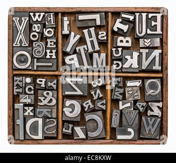 Alphabet et d'autres symboles en vieux métal impression type de blocs dans un typographe rustique en bois fort Banque D'Images