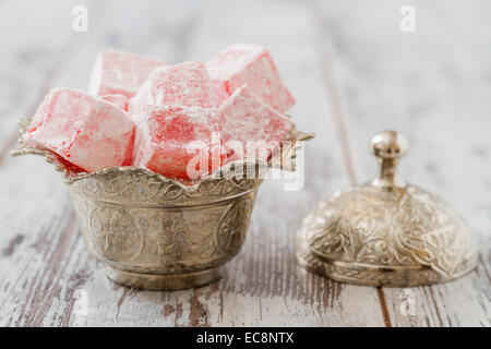 Aromatisé Rose loukoum dans un bol en argent sur fond blanc en bois Banque D'Images