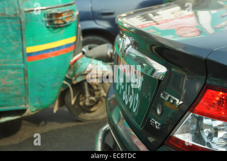 Contraste entre l'ancien et d'un rickshaw gnc nouvelle voiture de luxe, Dhaka, Bangladesh Banque D'Images