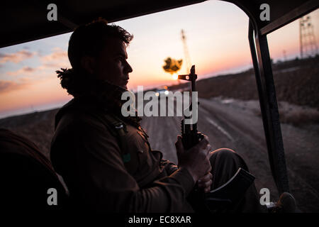 Erbil. Dec 10, 2014. Un combattant kurde se trouve dans un véhicule en direction de la ligne de front avec de soi-disant Etat islamique dans le sud-ouest de banlieue de Kirkouk dans le nord de l'Iraq, le 10 décembre 2014. © Chen Xu/Xinhua/Alamy Live News Banque D'Images