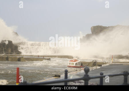 Bushmills, Irlande du Nord, Royaume-Uni. 10 Dec, 2014. un petit bateau de pêche se débat avec les amarres comme des vagues d'envahir l'Irlande du Nord Le port de Portrush. L'intense tempête ou une bombe météorologique a été causée par une chute rapide de la pression (plus de 24 millibars en 24 heures). Crédit : Brian Wilkinson/Alamy Live News Banque D'Images