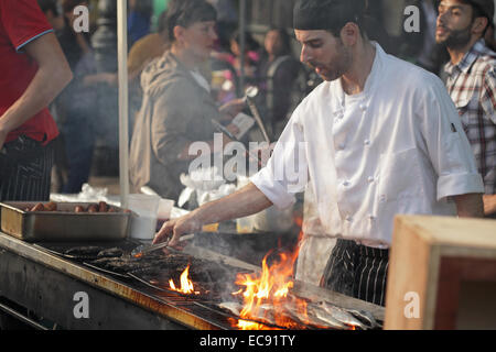 Man grilling sardines fraîches sur un barbecue sur Atlantic Avenue à Brooklyn lors d'une foire de rue Banque D'Images