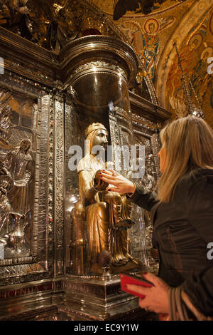 Adorateur woman touching la Vierge Noire de Montserrat statue en basilique de monastère de Montserrat en Catalogne, Espagne Banque D'Images