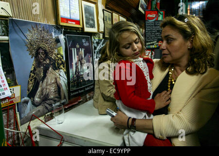 Femme avec enfant Seville bar à l'intérieur pendant la Semana Santa (Semaine Sainte), Séville, Andalousie, Sud de l'Espagne, l'Europe. Banque D'Images