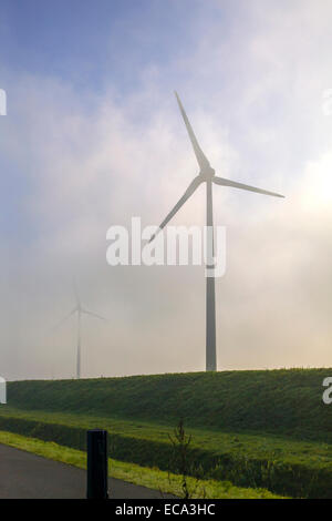 Éoliennes sur une digue dans le brouillard Banque D'Images