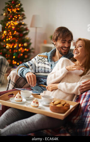 Joyeux jeune homme et femme en riant tout en prenant le thé Banque D'Images