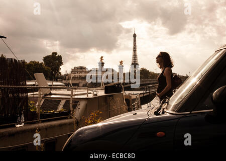 Femme enceinte seule à Paris, sans doute la plus romantique des villes du monde. Dans l'avant-plan, un mini Coupé S. Banque D'Images