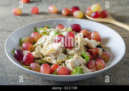 Mélanger avec la salade de poulet et les raisins sur le plat blanc Banque D'Images