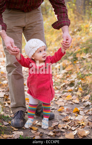 Une petite fille de un an apprend à marcher avec l'aide de son père à Kalispell, Montana. Banque D'Images