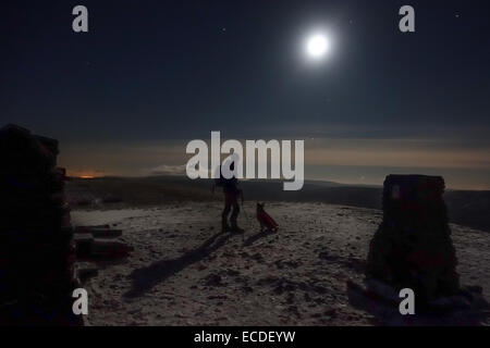 Montée totale de lune de Pen-y-ghent mountain dans le Yorkshire Dales. C'est sur le sommet après une ascension de nuit. Winter walker et chien de compagnie. UK Banque D'Images