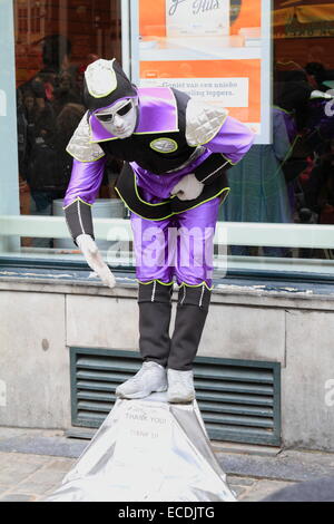 Artiste mime de rue de l'homme robe violet et blanc visage peint. Bruxelles, Belgique Banque D'Images