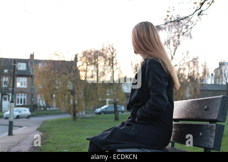 Vue arrière plan sur une jeune femme assise sur un siège à l'écart de l'appareil photo. Banque D'Images