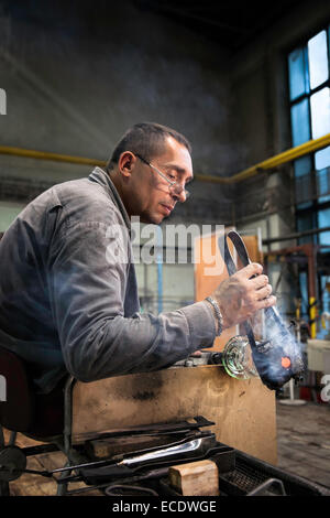 Homme souffleur de verre à l'usine de verre Moser et l'artisanat du verre soufflé dans des gobelets de cristal, Karlovy Vary (Karlsbad), République Tchèque Banque D'Images