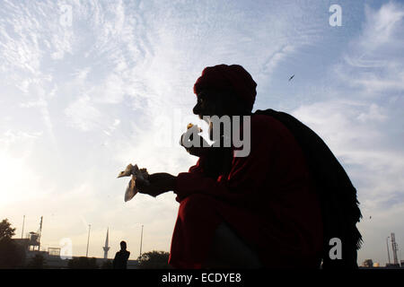 Lahore, Pakistan's Lahore. Dec 11, 2014. Un dévot musulman pakistanais mange dans le sanctuaire de Hazrat Ali Bin Usman, populairement connu sous le nom de Data Gunj Bakhsh, au cours de l'assemblée 'urs' fête religieuse dans l'est de Lahore au Pakistan, le 11 décembre 2014. Credit : Jamil Ahmed/Xinhua/Alamy Live News Banque D'Images