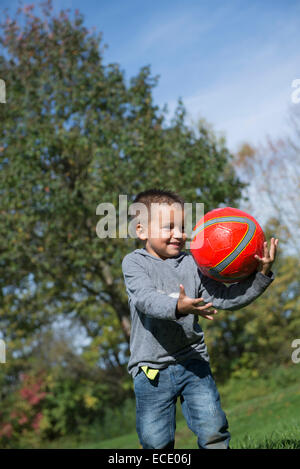 Jeune garçon heureux football rouge capture Banque D'Images