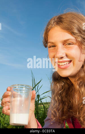 Girl (12-13) holding verre de lait, smiling, portrait, close-up Banque D'Images