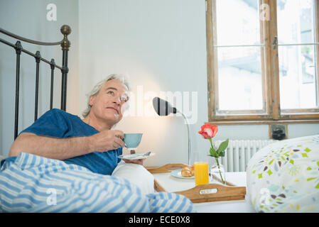 Man having breakfast in bed Banque D'Images