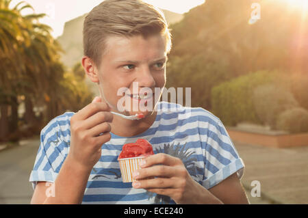 Adolescent coucher du soleil la consommation de crème glacée de l'été Banque D'Images