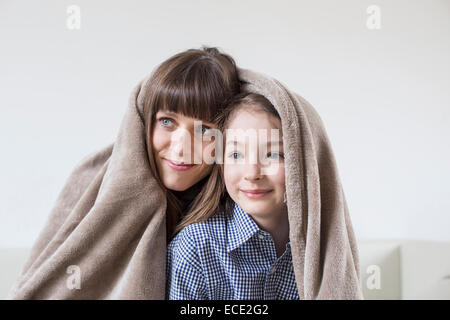 Mère et fille recouverte d'une couverture, smiling Banque D'Images