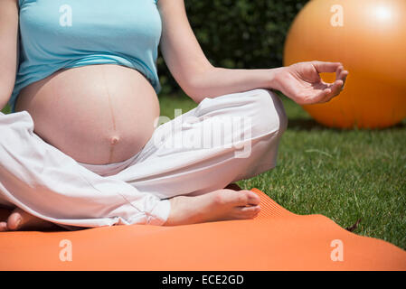 Close-up méditant femme enceinte garden Banque D'Images